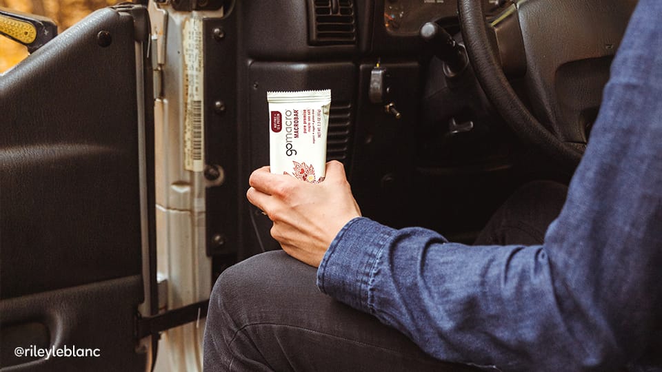 Man sitting in car holding GoMacro MacroBar