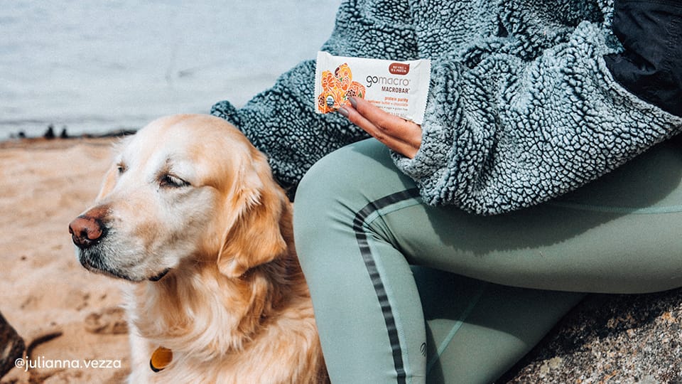 Woman holding a GoMacro MacroBar next to dog