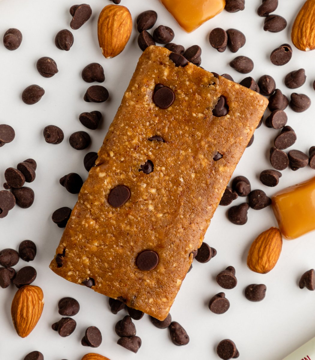 GoMacro Salted Caramel Chocolate Chip Macrobar Mini surrounded by chocolate chips