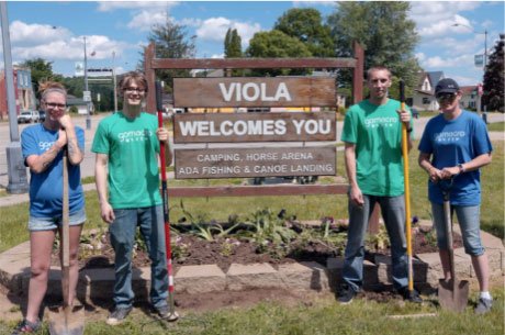 People standing next to sign that says
