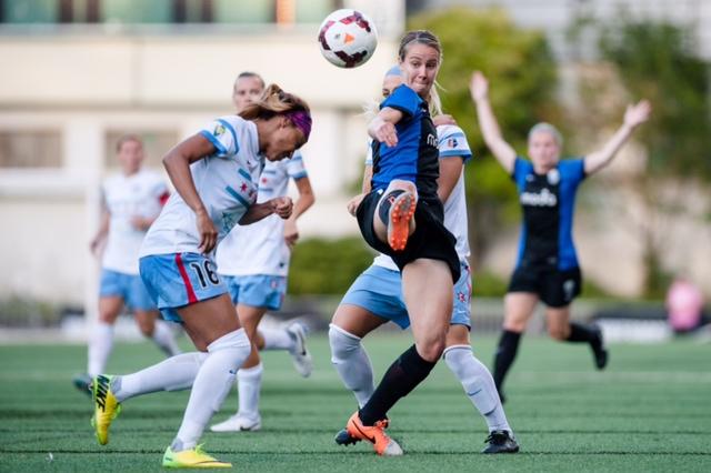 Beverly Goebel kicking a soccer ball in the air