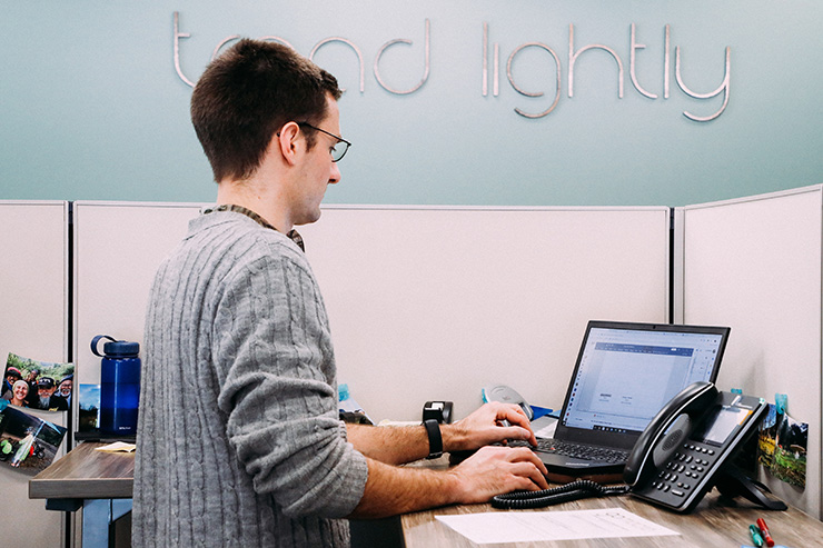 stand-up desk with employee working on laptop