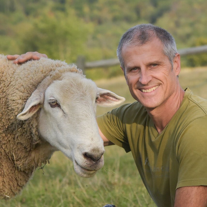 Gene Bauer next to sheep on Farm Sanctuary