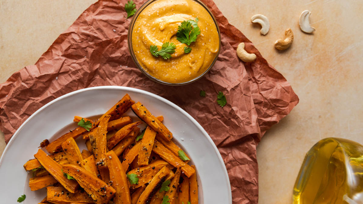 A plate of sweet potatoes with a side of cashew sriracha aioli