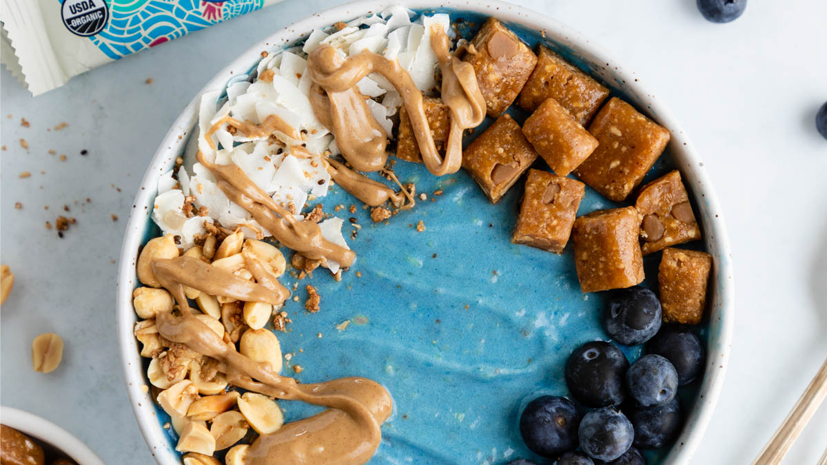 Blue protein smoothie bowl topped with GoMacro peanut butter bar