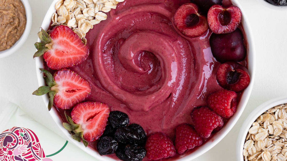 Fruit smoothie bowl next to GoMacro sunny uplift bar