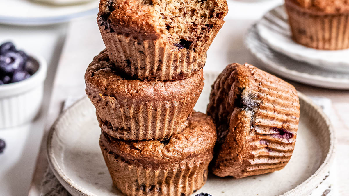 Three vegan blueberry muffins stacked on top of each other