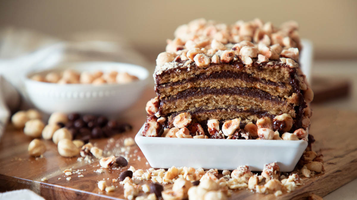 A slice of chocolate cake topped with roasted hazelnut