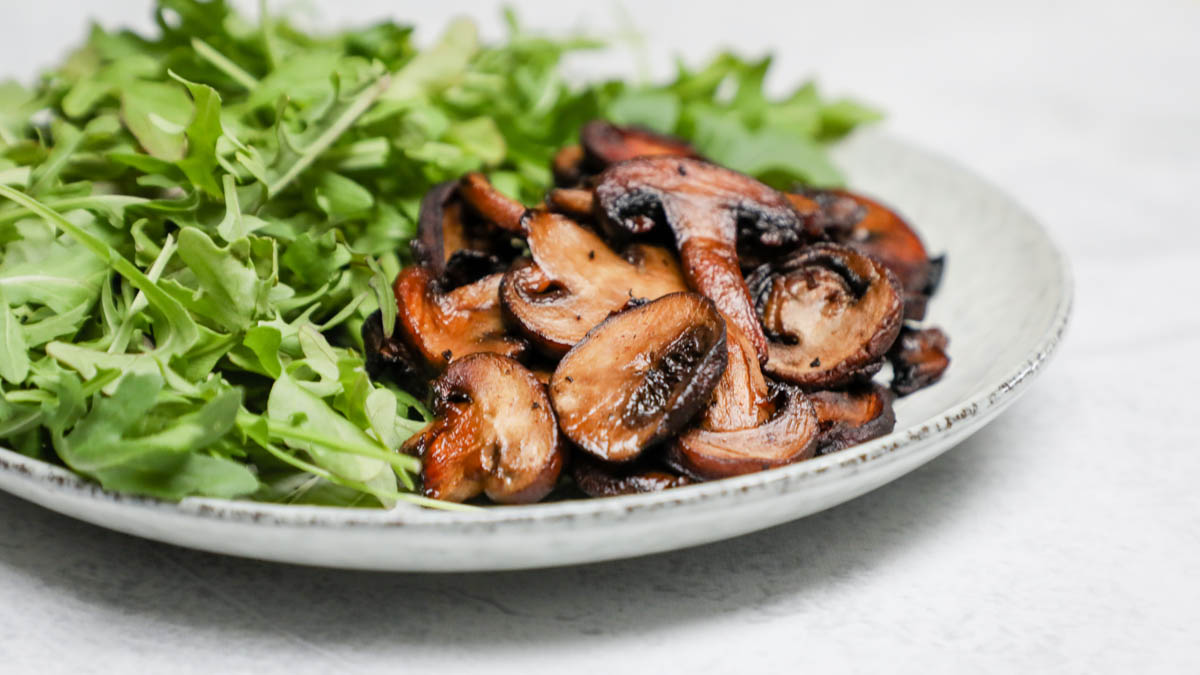 Balsamic mushrooms and arugula on a plate