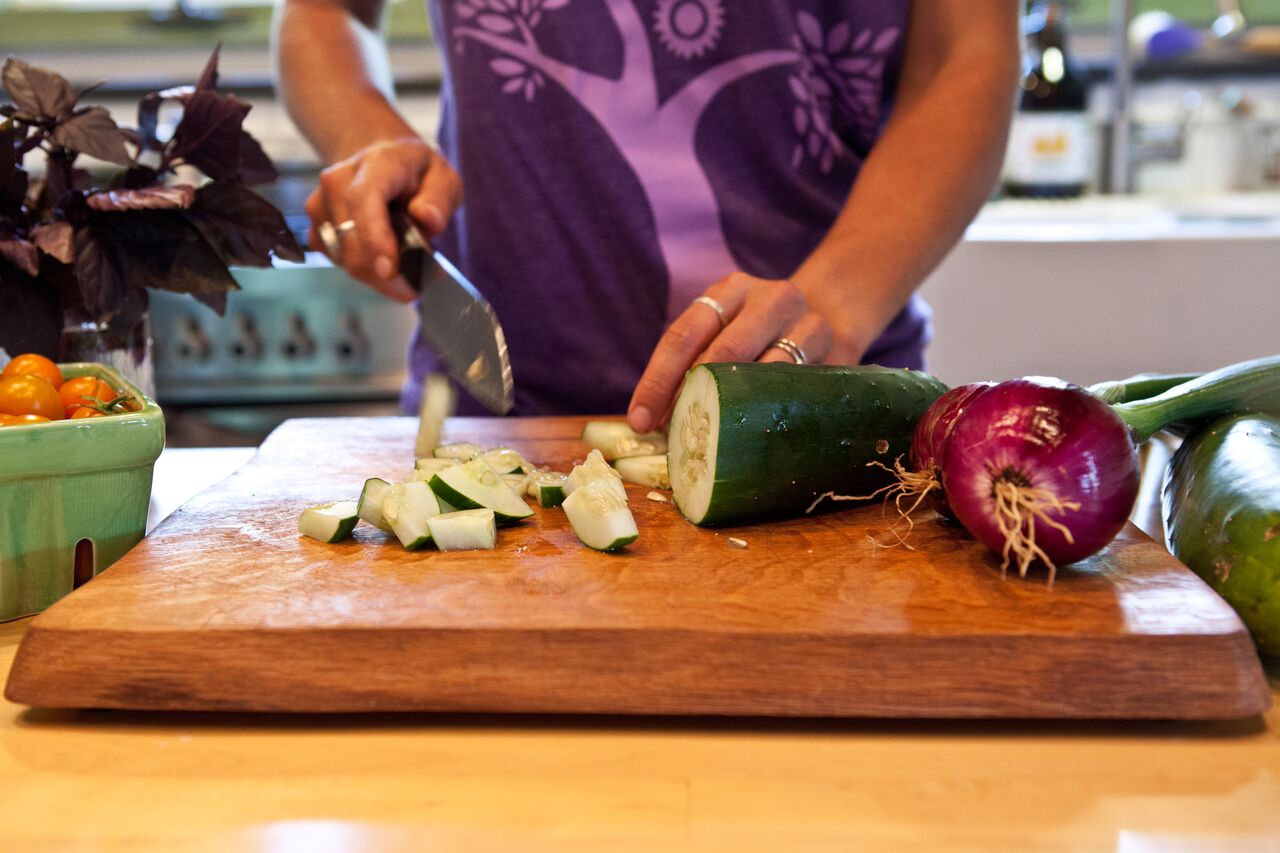 Cucumber being chopped on a cutting board