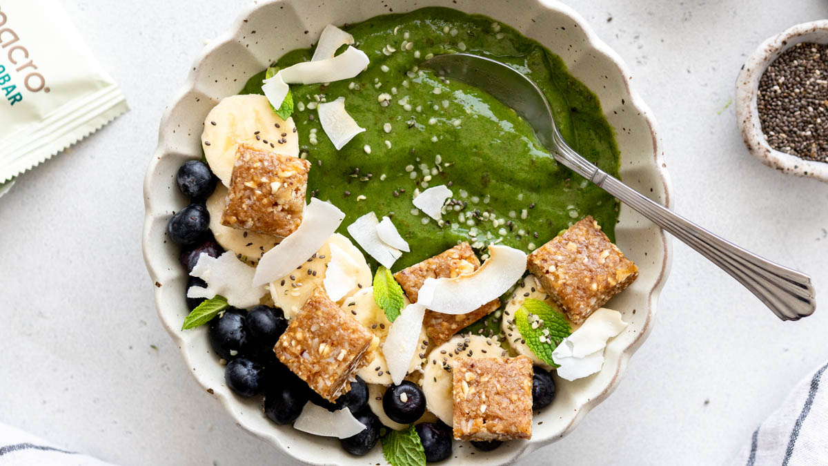 Green peanut butter smoothie bowl next to GoMacro protein bars