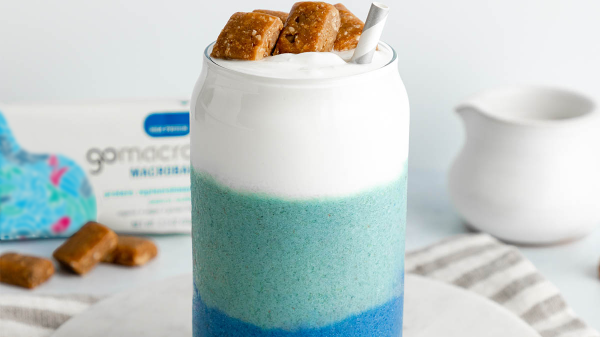 Smoothie layered with blue spirulina, coconut, and peanut butter protein bars
