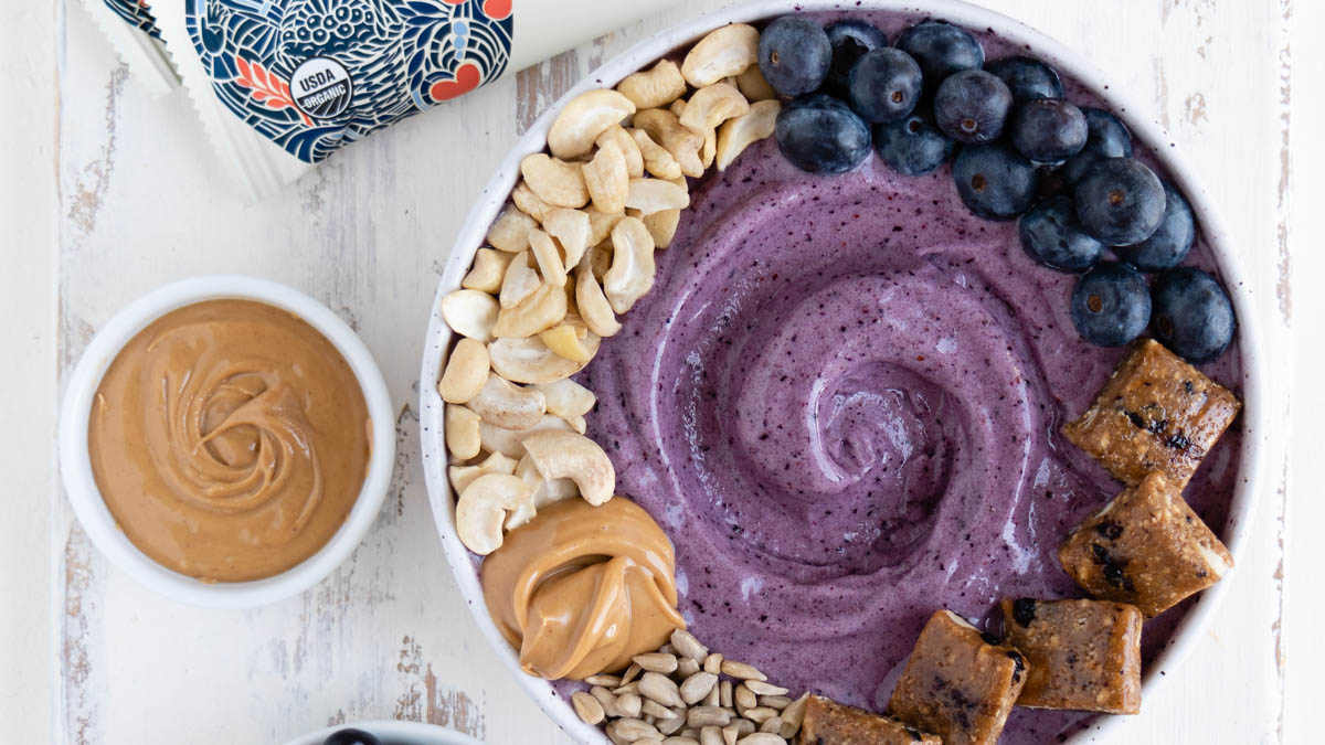 Blueberry smoothie bowl topped with GoMacro blissful daybreak bar