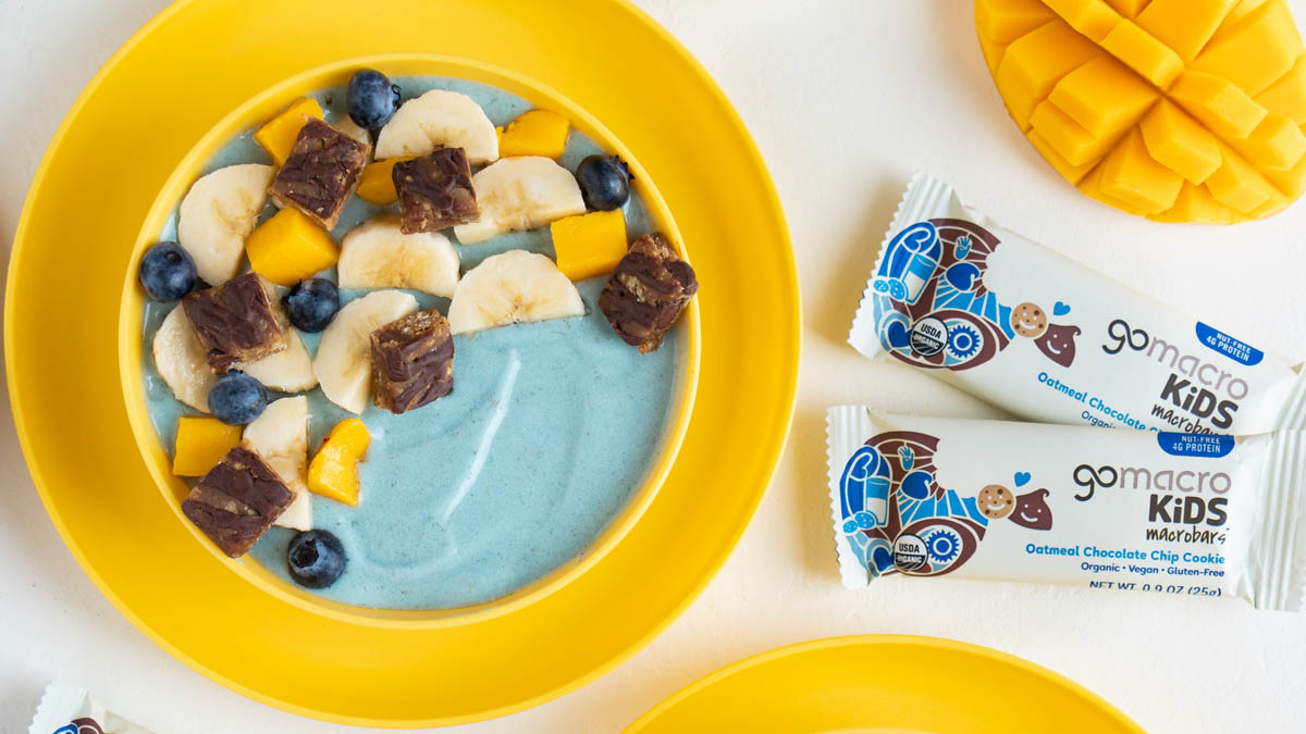 Blue mango smoothie bowl topped with bananas and oatmeal protein bar