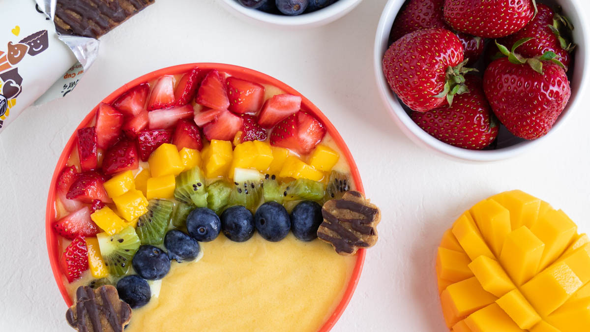 Pineapple and peach smoothie bowl topped with fruits