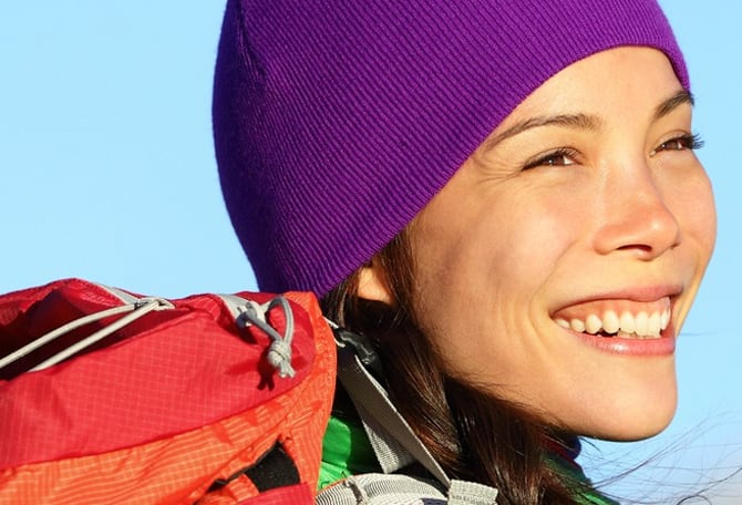 Woman smiling outdoors with purple hat on
