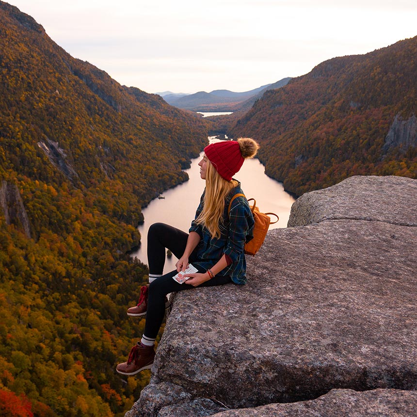 Woman on mountain peak holding GoMacro Macrobar