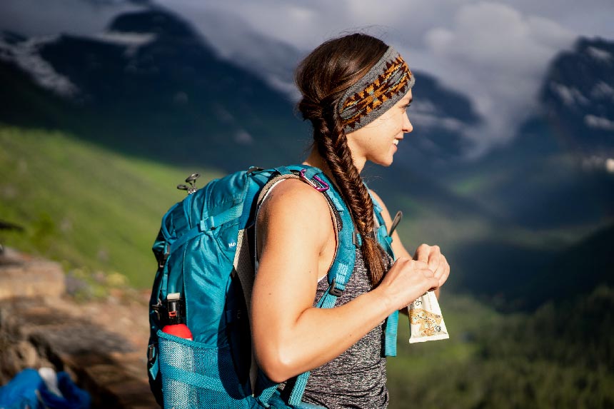Woman hiking holding a GoMacro MacroBar