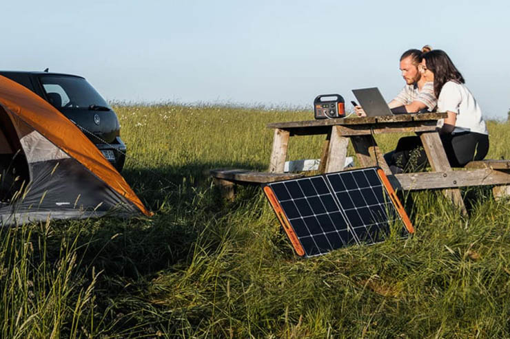Man and woman camping with portable solar panels