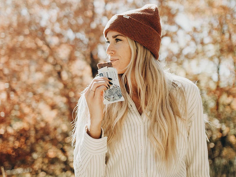 GoMacro Ambassador eating a GoMacro MacroBar outside