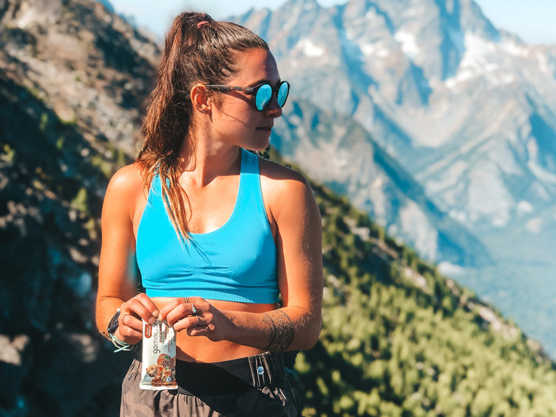 GoMacro Ambassador in nature holding a GoMacro MacroBar