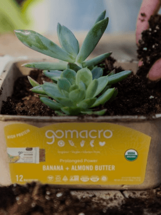 Hand putting soil into a Banana + Almond Butter MacroBar Tray